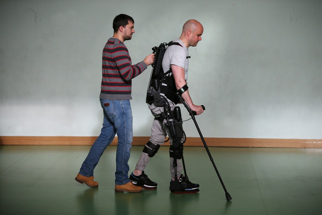 Mark Pollock is helped by his assistant as he walks using the Ekso Bionics robotic exoskeleton at Trinity College in Dublin.
