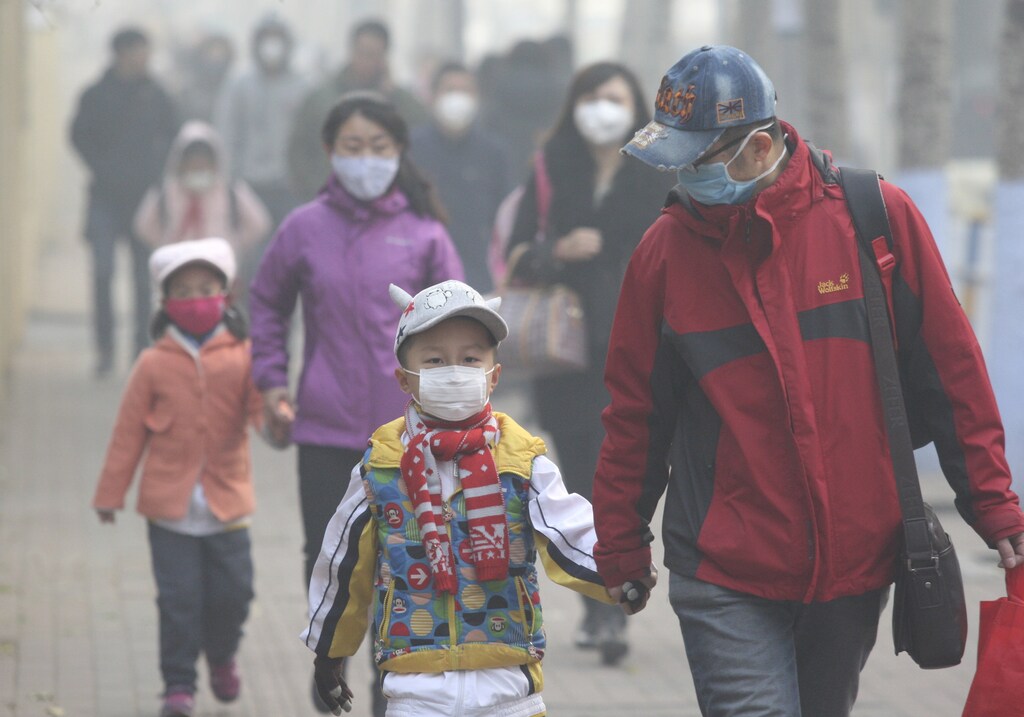 Young students and their parents wearing masks walk along a street on a hazy day in Harbin, Heilongjiang province, China, November 3, 2015. Some kindergartens and schools were closed as severe air pollution hit northeastern Chinese city of Harbin on Tuesday, local media reported. REUTERS/Stringer CHINA OUT. NO COMMERCIAL OR EDITORIAL SALES IN CHINA - GF20000043621