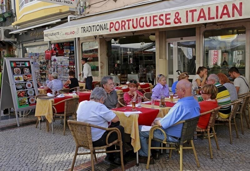 People eat at a restaurant in Lisbon, Portugal, September 23, 2015. Winning the vote of the cooks and waiters dishing out succulent grilled fish and spicy chicken at Portugal's restaurants could make all the difference in the country's tight Oct. 4 election. The restaurant sector is a huge provider of jobs in this food-worshipping southern European nation. It was also among the hardest hit by austerity imposed by centre-right premier Pedro Passos Coelho as part of efforts to shake off the 2009 sovereign debt crisis that also afflicted Spain, Greece and Cyprus. Picture taken September 23, 2015. REUTERS/Hugo Correia - GF10000219093