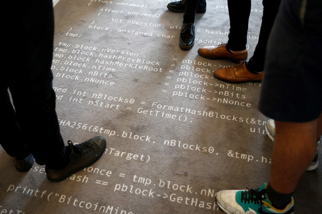 Employees of the Fintech N26 (Number26), stand on a carpet with the Bitcoin source code printed on it in Berlin, Germany, August 19, 2016. REUTERS/Axel Schmidt - RTX2M039