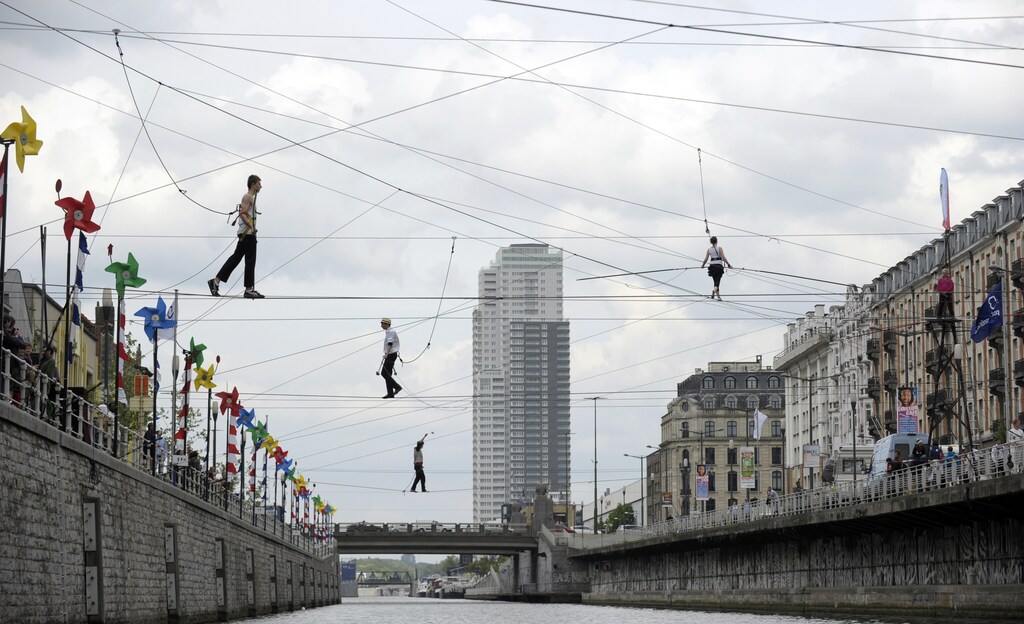 Tightrope walkers perform above a canal in Brussels April 26, 2014. Approximately forty-four tightrope walkers made an attempt to cross the canal during a performance. REUTERS/Laurent Dubrule (BELGIUM - Tags: SOCIETY TPX IMAGES OF THE DAY) - RTR3MQ6J
