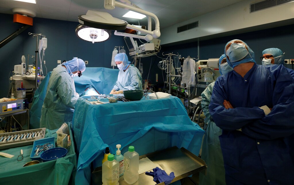A heart surgeon, with members of a medical team perform an operation in an operating room at the Saint-Augustin clinic in Bordeaux, France, October 25, 2018. REUTERS/Regis Duvignau - RC14487E3C50