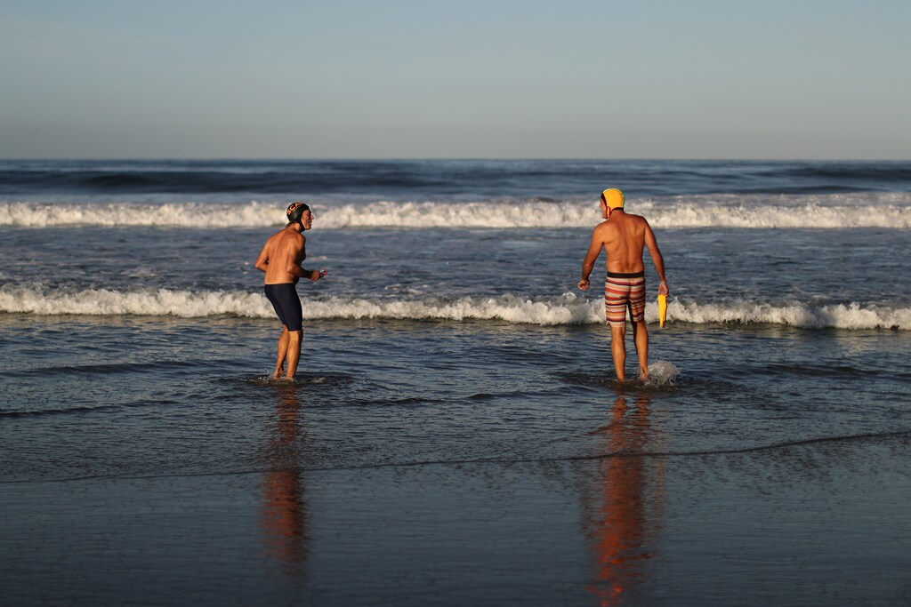 La gente nada en el Océano Pacífico el primer día de la apertura de las playas del condado de Los Ángeles, mientras continúa el brote global de la enfermedad coronavirus (COVID-19), en Santa Mónica, California, EE.UU., el 13 de mayo de 2020.
