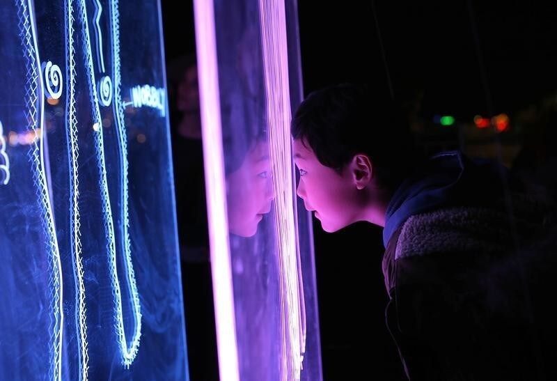 A boy rests his head on an installation titled 'Connections' during the Vivid Sydney festival of light and sound in Sydney, Australia, May 27, 2017. Picture taken May 27, 2017. REUTERS/Steven Saphore - RTX37XTF