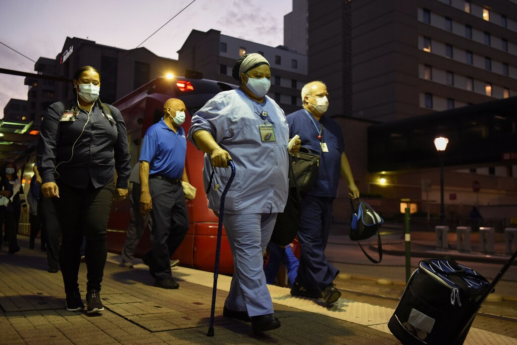 Healthcare workers walk through the Texas Medical Center during a shift change as cases of the coronavirus disease (COVID-19) spike in Houston, Texas, U.S., July 8, 2020. REUTERS/Callaghan O'Hare - RC25PH93WYMO
