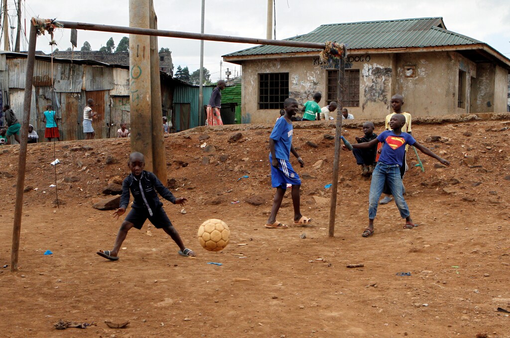 A goalkeeper attempts to save the ball at a makeshift soccer pitch near Mathare valley slums in Nairobi, Kenya May 5, 2018. The eyes of the world will turn to Russia this week for the four-yearly gathering of soccer's superstars but it is away from the glitzy new stadiums built at a staggering cost you must look to find the sport's beating heart; to the dusty streets and poverty-wracked neighbourhoods where the simple act of scoring a goal can still transcend the grind of everyday life. Picture taken May 5, 2018. REUTERS/Njeri Mwangi TO FIND ALL PICTURES SEARCH "SOCCER-WORLDCUP/STREETGOALS\ - RC1A430F6420