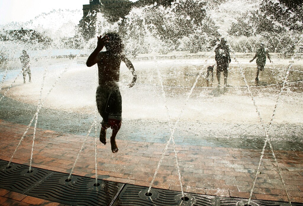 Six year-old Otis Walker jumps through the fountain at the Christian Science Center on a hot summer day in Boston, Massachusetts July 17, 2006. REUTERS/Brian Snyder (UNITED STATES) - GM1DTBMVPIAA