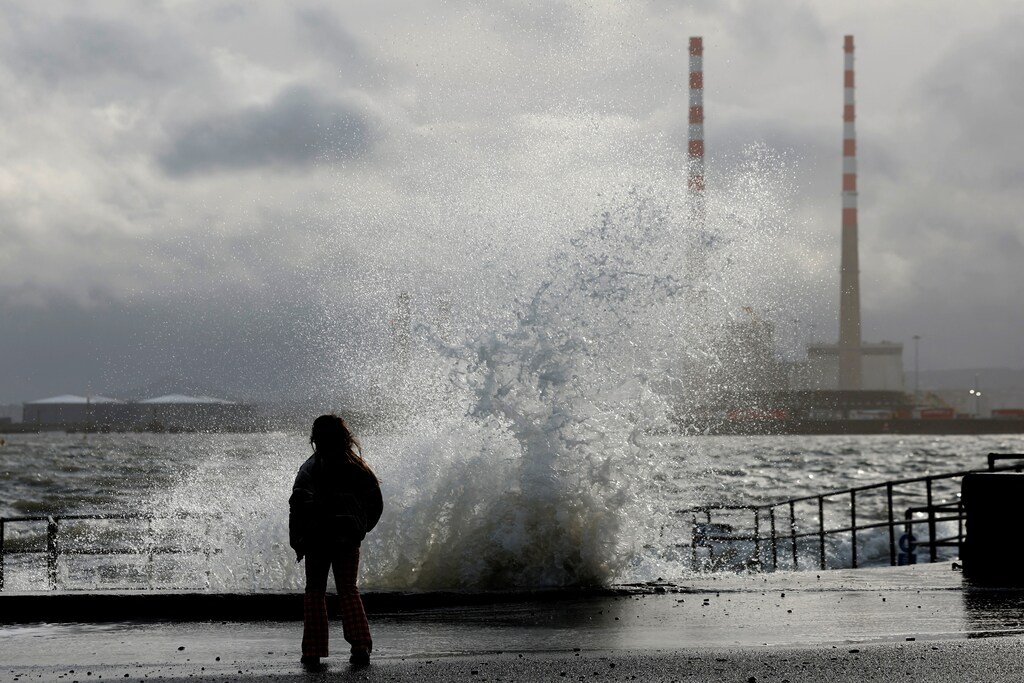 A child stands looking at a wave overtopping on Clontarf promenade during stormy weather with high winds, in Dublin, Ireland, January 20, 2026. REUTERS/Clodagh Kilcoyne