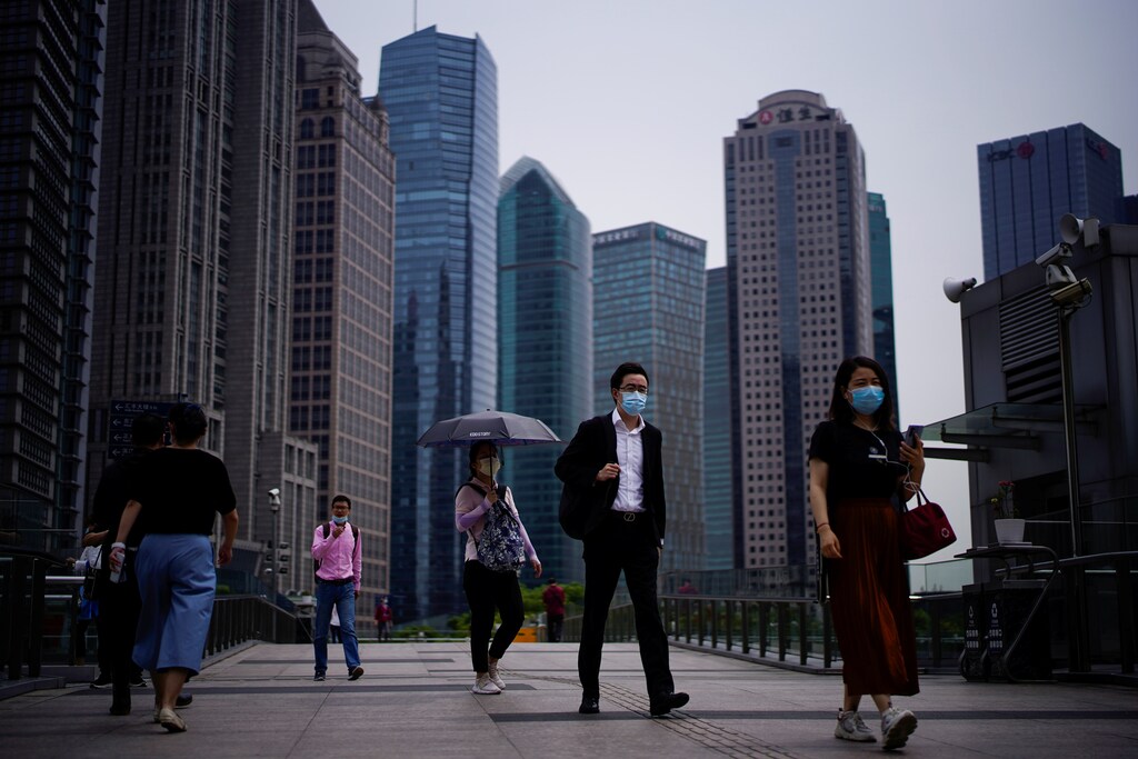 People wearing protective face masks walk past office buildings in Lujiazui financial district in Pudong, in Shanghai, following the coronavirus disease (COVID-19) outbreak, China June 4, 2020. REUTERS/Aly Song - RC2F2H9XOJG3