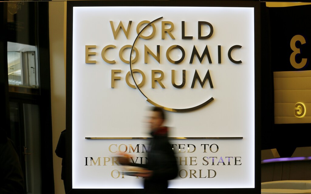 A man walks past the official logo of the World Economic Forum (WEF) inside the Congress Hall at the Swiss Alpine resort of Davos January 22, 2013. The annual World Economic Forum held from January 23 to 27, 2013 in Davos. REUTERS/Pascal Lauener (SWITZERLAND - Tags: POLITICS BUSINESS) - BM2E91M0Y9Q01