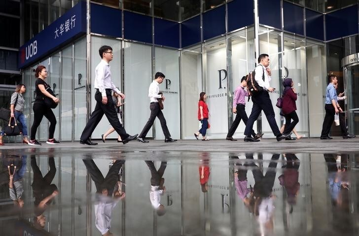 Office workers pass a UOB bank branch in Singapore's central business district April 27, 2017. REUTERS/Edgar Su TPX IMAGES OF THE DAY