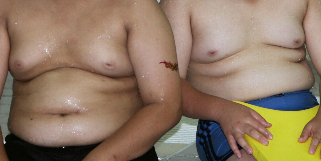 Children sit on a pool side during a summer camp for overweight children which organised by Gangseo district office, in Seoul July 28, 2006. About 12 percent of students attending elementary, middle and high schools in Seoul are overweight due to a rapid change in eating habits, local media reported. REUTERS/Kim Kyung-Hoon (SOUTH KOREA) - RTR1FW5Z