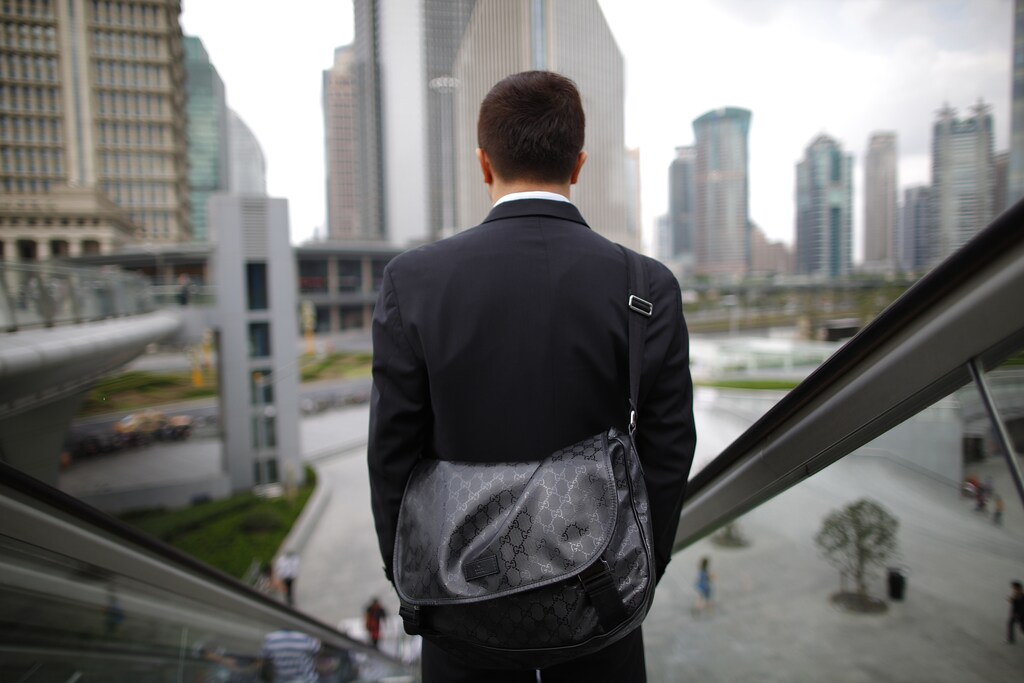 A business man rides an escalator in the financial district of Pudong in Shanghai September 21, 2011. REUTERS/Aly Song (CHINA - Tags: CITYSPACE SOCIETY) - GM1E79R0VH401