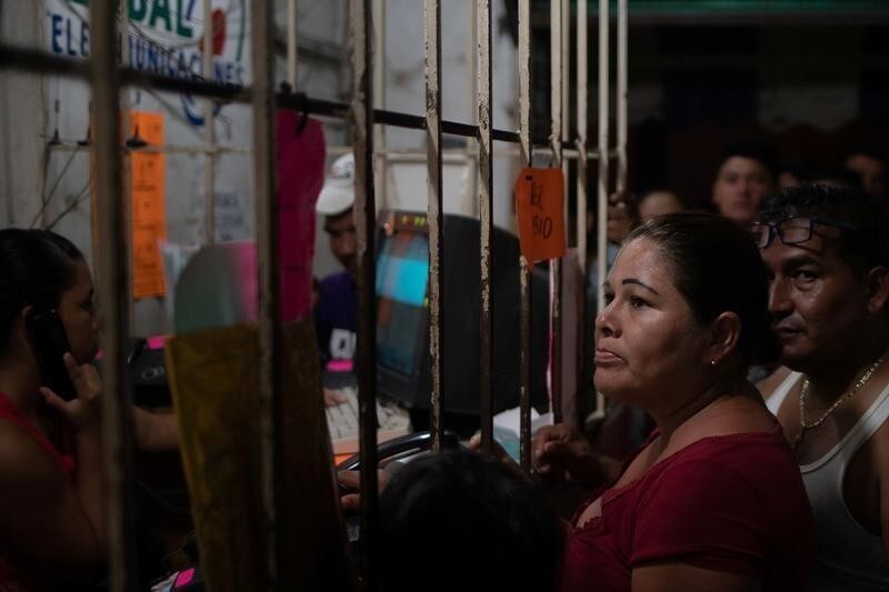 Migrants from Central America, en route to the United States, stand in line to make calls to relatives from a phone shop after they arrive in Huixtla, Mexico October 22, 2018.