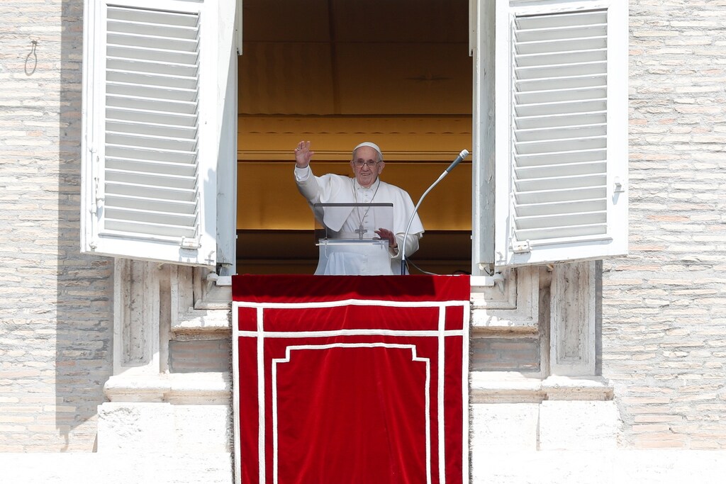 Pope Francis waves as he arrives to lead Angelus prayer from his window at the Vatican following intestinal surgery, at the Vatican.