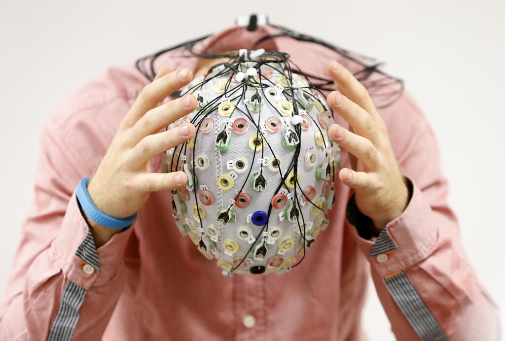 Test person Niklas Thiel poses with an electroencephalography (EEG) cap which measures brain activity, at the Technische Universitaet Muenchen (TUM) in Garching near Munich September 9, 2014. The researchers from TUM and the Technische Universitaet Berlin (team Phypa) try to find ways to control an airplane with computer translated brain impulses without the pilot touching the plane's controls. The solution, if achieved, would contribute to greater flight safety and reduce pilots' workload. Picture taken September 9, 2014. REUTERS/Michaela Rehle (GERMANY - Tags: SCIENCE TECHNOLOGY SOCIETY TPX IMAGES OF THE DAY) - BM2EA9914OF01