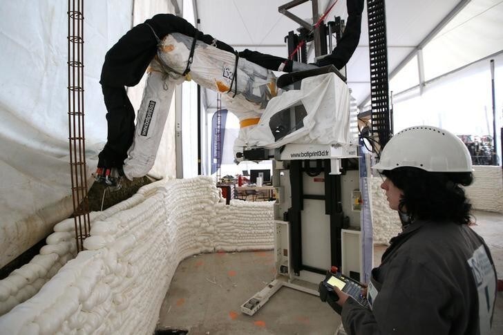 An employee works to build a 3D printed social housing building called "Yhnova", using a construction 3D printing technique known as BatiPrint3D and developed by researchers from the University of Nantes, in Nantes, France, September 19, 2017. REUTERS/Stephane Mahe
