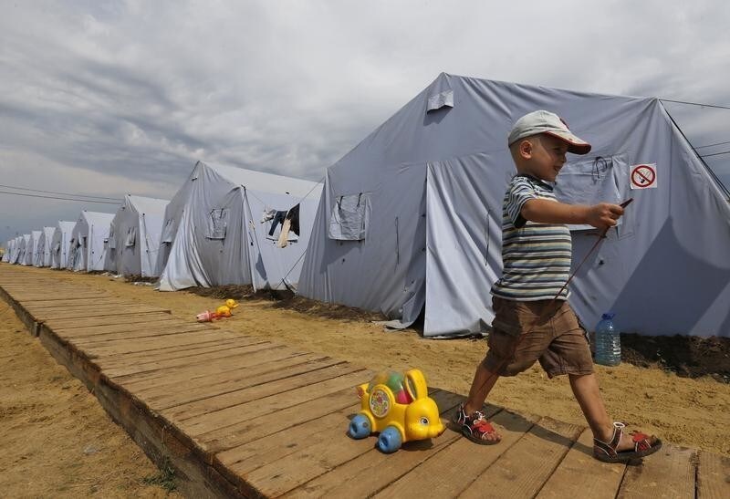 Alexander, 4, walks with a toy at a temporary tent camp set up for Ukrainian refugees outside Donetsk, located in Russia's Rostov region near the Russian-Ukrainian border, August 18, 2014.