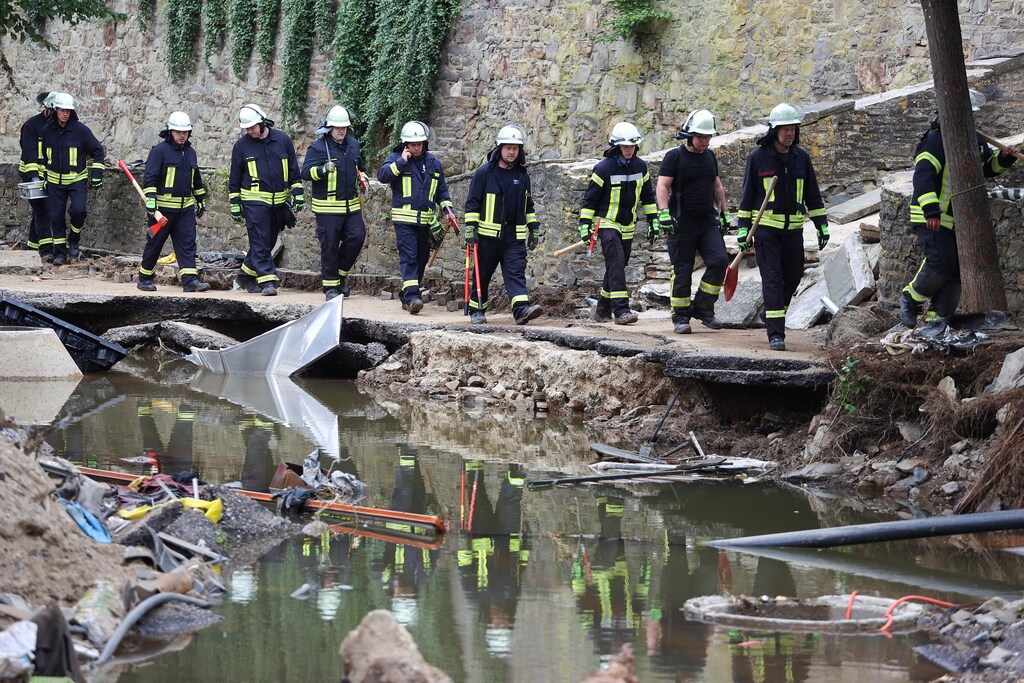 firefighters walk in an area affected by floods caused by heavy rainfalls in Bad Muenstereifel, Germany.