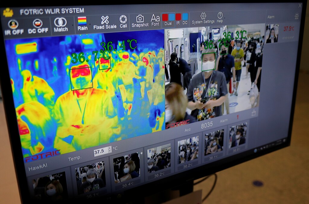People are seen through the screen of a thermal scanner during the 41st Bangkok International Motor Show, after the Thai government eased measures to prevent the spread of the coronavirus disease (COVID-19), in Bangkok, Thailand, July 15, 2020. REUTERS/Jorge Silva - RC2JTH935U5K