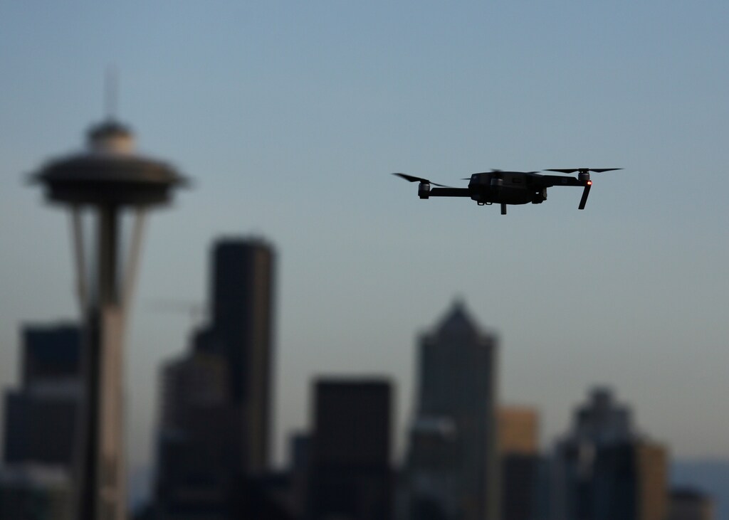 A drone hovers at a viewpoint overlooking the Space Needle and skyline of tech hub Seattle, Washington, U.S. February 11, 2017. REUTERS/Chris Helgren - RC12CDBCF690