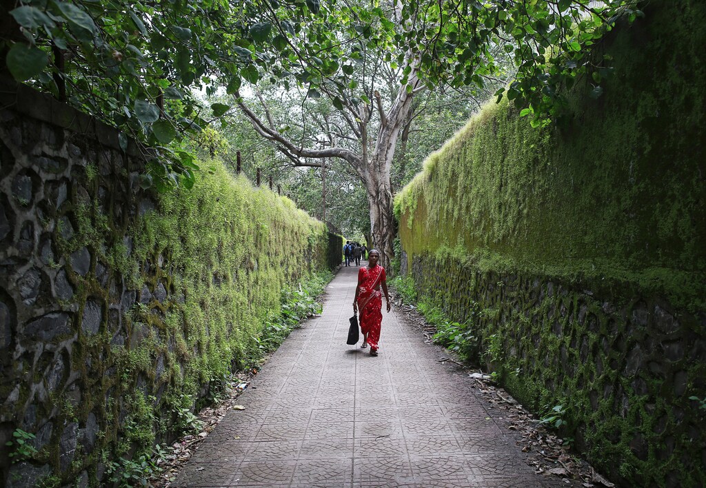 A woman commuter walks on a pathway next to a railway station in central Mumbai September 17, 2014. REUTERS/Danish Siddiqui (INDIA - Tags: SOCIETY) - GM1EA9H1MXK01