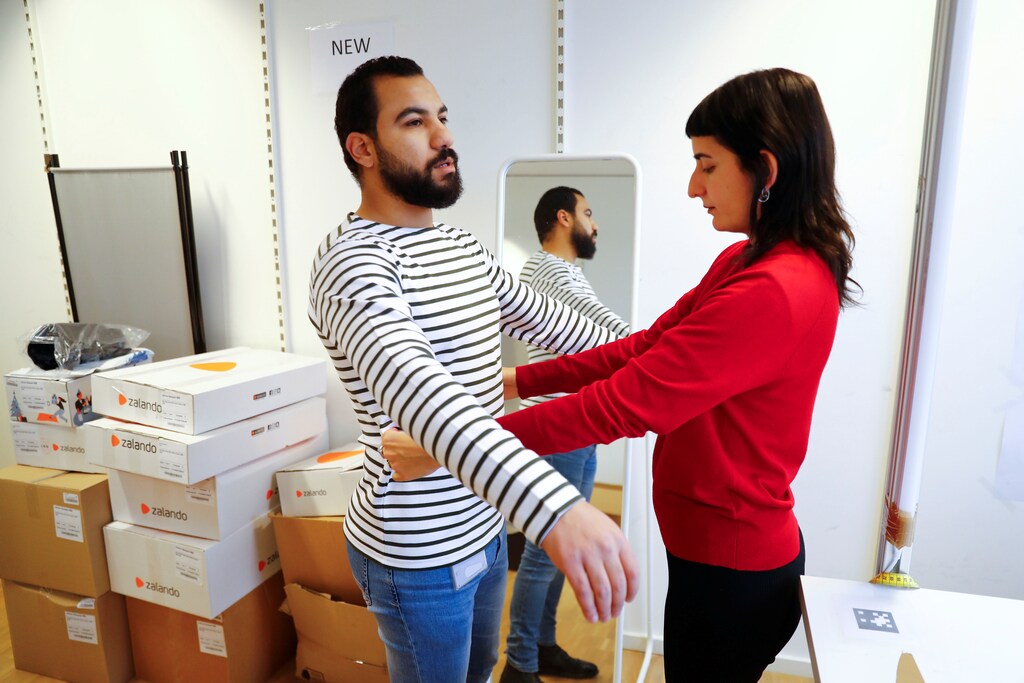 Modelos en forma comprueba las tallas de una camiseta que se vende en la tienda online del minorista de moda Zalando en Berlín, Alemania, el 17 de diciembre de 2018.