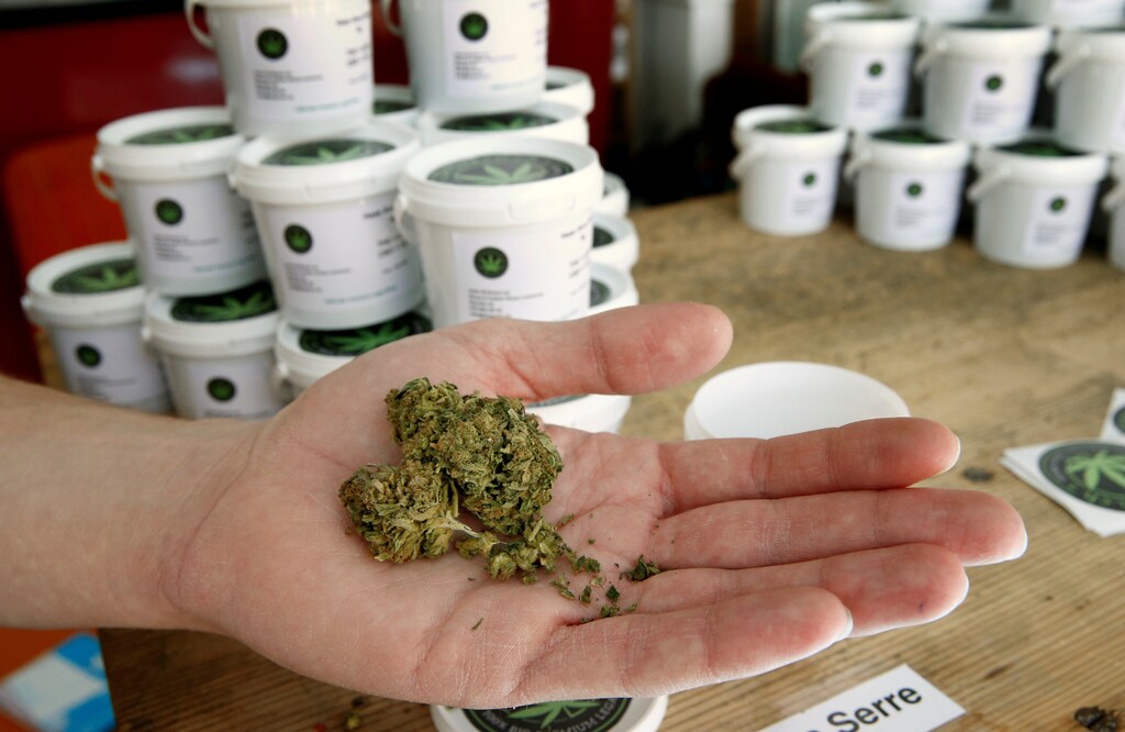 Paul Monot, co-founder of Dr Green, holds dried cannabis in his shop in Lausanne, Switzerland March 17, 2017. REUTERS/Denis Balibouse - RC181BF0B520