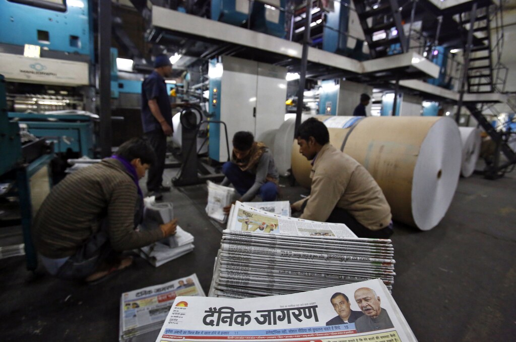 Employees sort Dainik Jagran newspapers inside its printing press in Noida, on the outskirts of New Delhi February 26, 2014. India's northern Hindi-speaking belt, home to around half a billion people, is taking off after decades of trailing industrialised seaboard states in the west and south. Picture taken February 26, 2014. To match story INDIA-BUSINESS/NORTH REUTERS/Anindito Mukherjee (INDIA - Tags: MEDIA BUSINESS POLITICS) - RTR3G02T