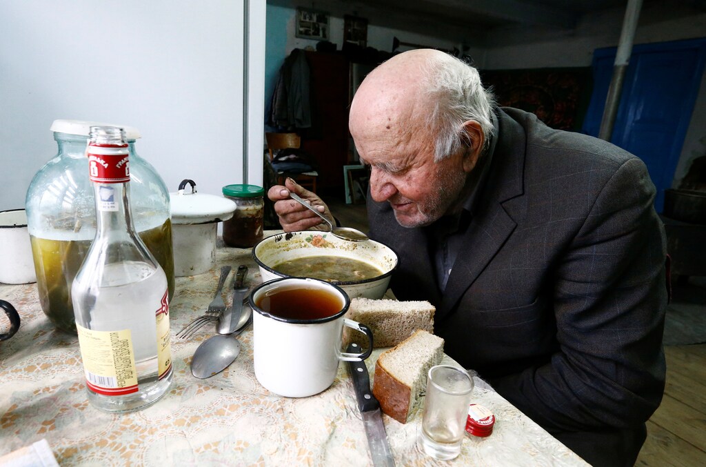 Ivan Shamyanok, 90, eats lunch in his house in the village of Tulgovichi, near the exclusion zone around the Chernobyl nuclear reactor, Belarus April 2, 2016. Shamyanok says the secret to a long life is not leaving your birthplace even when it is a Belarusian village poisoned with radioactive fallout from a nuclear disaster. In April 1986, a botched test at a nuclear plant in Chernobyl, Ukraine, sent clouds of smouldering nuclear material across swathes of Europe and forced more than 100,000 people to leave a permanently contaminated "exclusion zone". April 26, 2016 marks the 30th anniversary of the worst nuclear meltdown in history. REUTERS/Vasily Fedosenko SEARCH "EXCLUSION IVAN" FOR THIS STORY. SEARCH "THE WIDER IMAGE" FOR ALL STORIES - D1AESYHONPAA