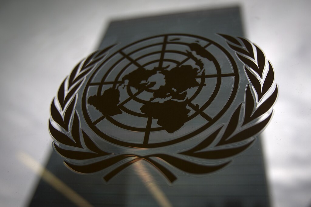 The United Nations headquarters building is pictured though a window with the UN logo in the foreground in the Manhattan borough of New York August 15, 2014.