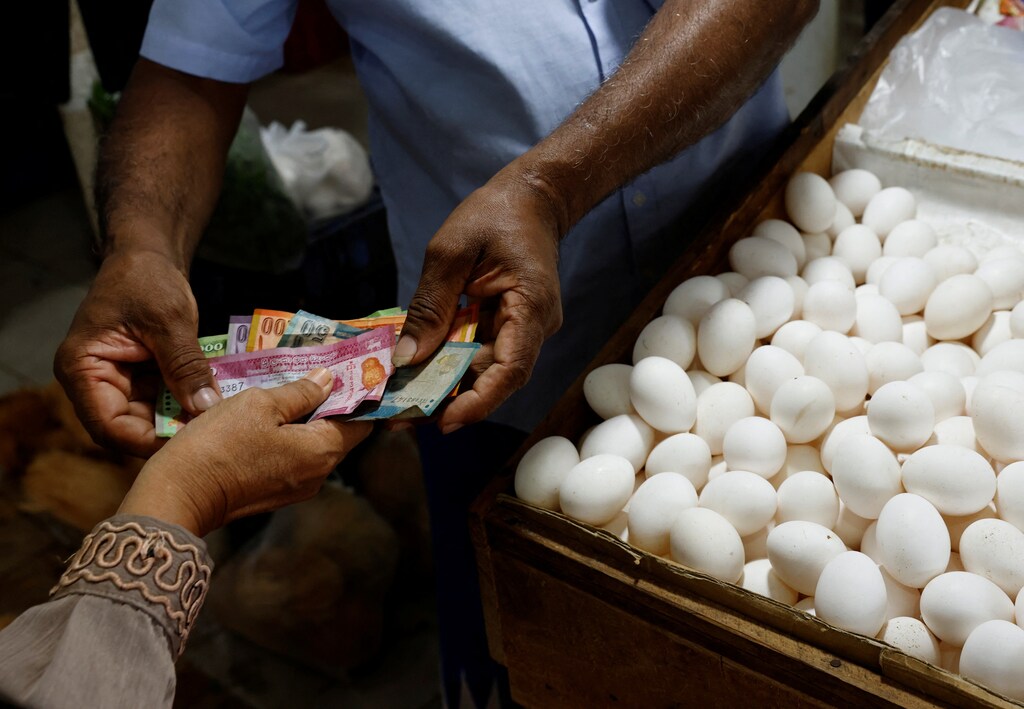 A vendor gives change to a customer after selling eggs amid the rampant food inflation, amid Sri Lanka's economic crisis, in Colombo, Sri Lanka, July 29 , 2022. REUTERS/Kim Kyung-Hoon