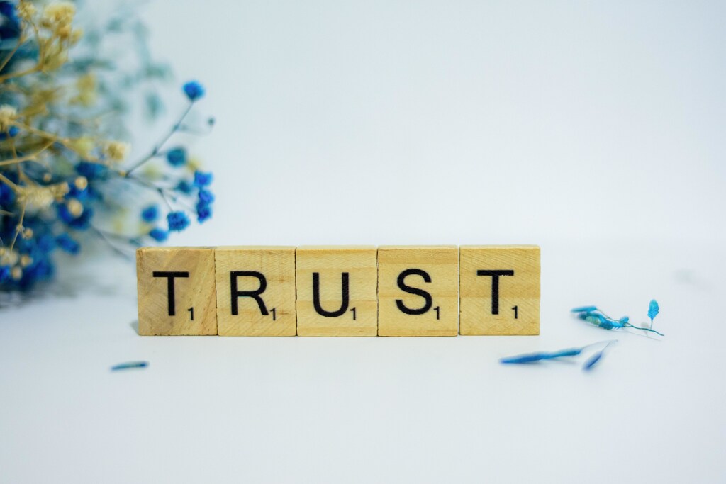 Scrabble tiles spelling out the word 'Trust'.