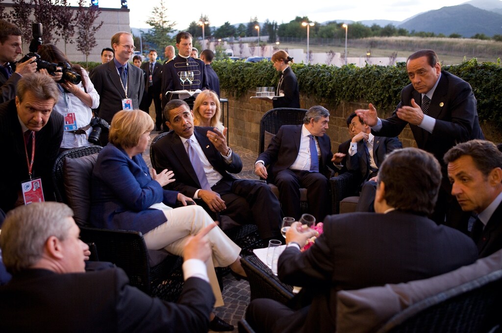 Canadian Prime Minister Stephen Harper, German Chancellor Angela Merkel, US President Barack Obama, UK Prime Minister Gordon Brown, Japanese Prime Minister Taro Aso, Italian Prime Minister Silvio Berlusconi, and French President Nicolas Sarkozy, (Russian representative not pictured) confer together while attending the G-8 summit in L'Aquila, Italy, July 8, 2009