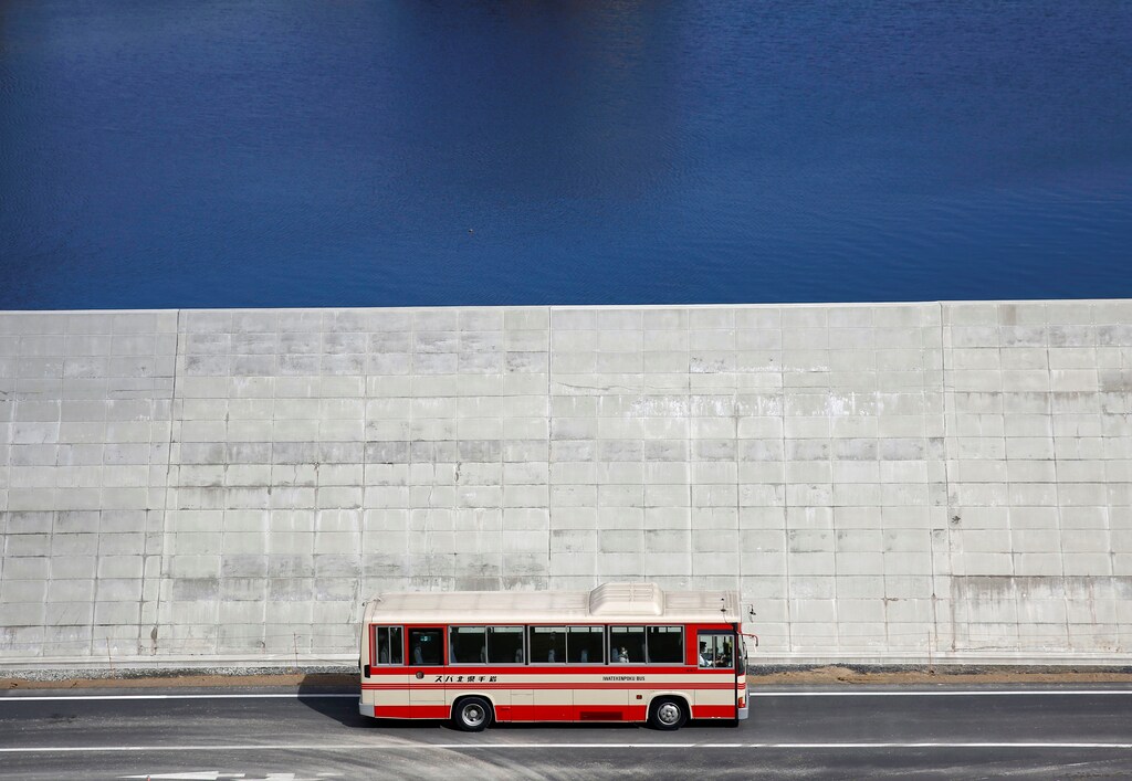 A bus is driven past a seawall in Yamada village, Iwate Prefecture, Japan, March 3, 2018