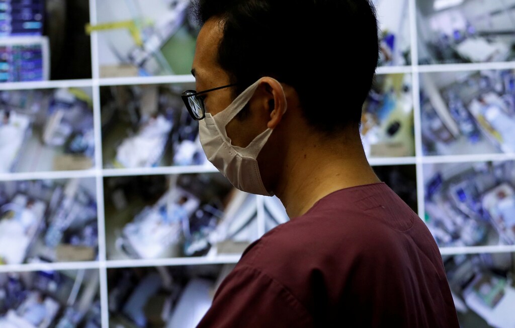 A medical worker wearing a protective face mask monitors remotely the live footages of patients at the Intensive Care Unit (ICU) ward for coronavirus disease (COVID-19) patients at St. Marianna Medical University Hospital in Kawasaki, south of Tokyo, Japan May 4, 2020. REUTERS/Issei Kato TPX IMAGES OF THE DAY - RC2GHG9P1REO
