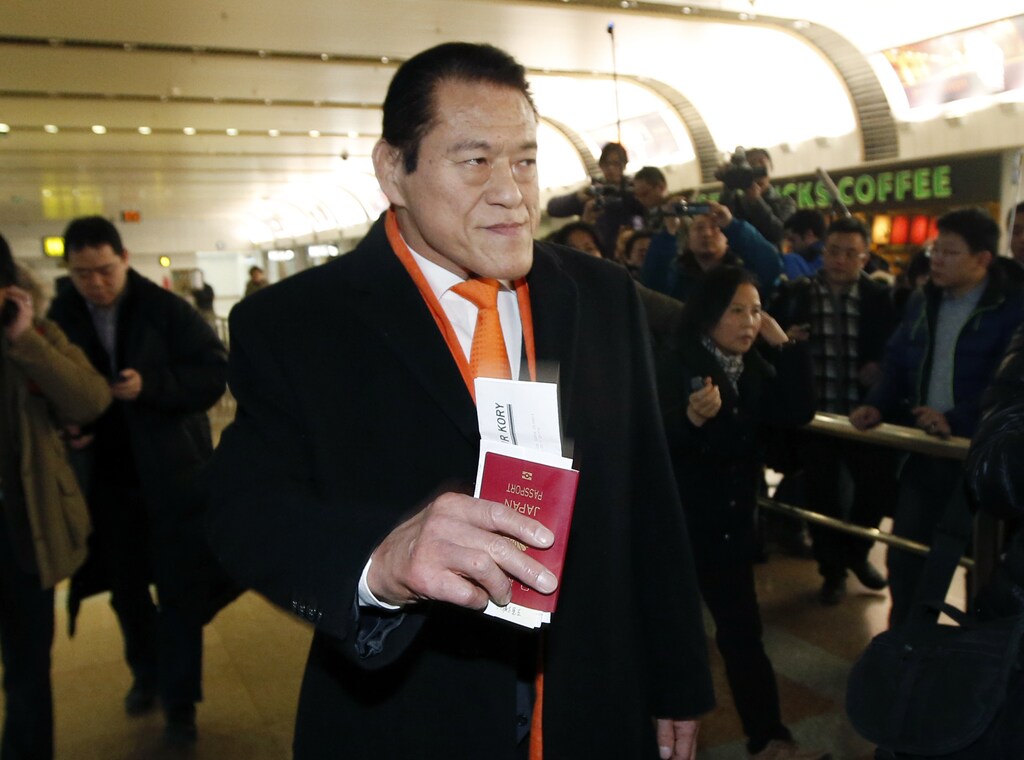 Former pro-wrestler turned lawmaker Antonio Inoki holds his Japanese passport upon his arrival from Pyongyang, at Beijing Capital International Airport January 16, 2014. Inoki's visit, which follows another high-profile trip by former NBA basketball star Dennis Rodman of the U.S., is likely to cause controversy as Japan has asked its citizens not to visit North Korea. REUTERS/Kim Kyung-Hoon (CHINA - Tags: SPORT POLITICS) - GM1EA1G10AF01