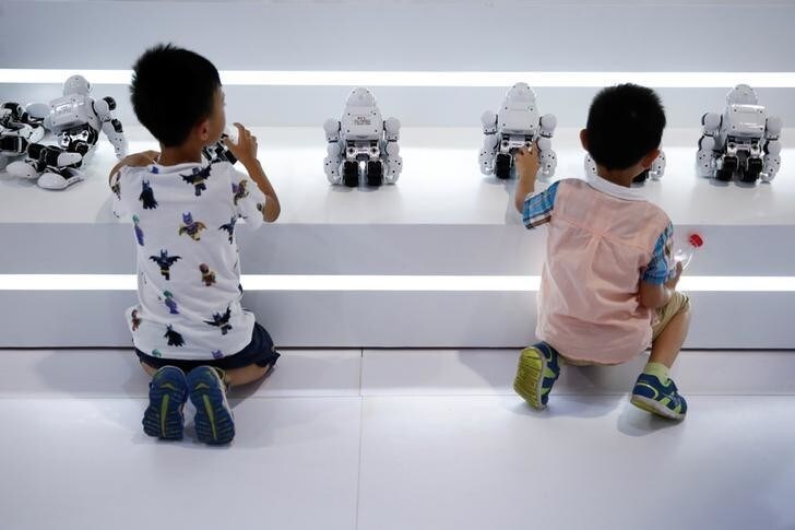 Children play with robots at the 2017 World Robot Conference in Beijing, China August 22, 2017. REUTERS/Thomas Peter