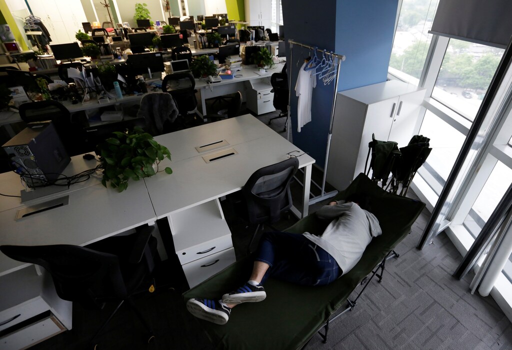 Kou Meng, product manager of RenRen Credit Management Co., sleeps on a camp bed at the office early morning, in Beijing, China, April 27, 2016. Office workers sleeping on the job is a common sight in China, where a surplus of cheap labour can lead to downtime at work. But in China's technology sector, where business is growing faster than many start-up firms can hire new staff, workers burn the midnight oil to meet deadlines and compete with their rivals. Some companies provide sleeping areas and beds for workers to rest during late nights. REUTERS/Jason Lee SEARCH "JASON SLEEP" FOR THIS STORY. SEARCH "THE WIDER IMAGE" FOR ALL STORIES - S1BETDIDDXAA
