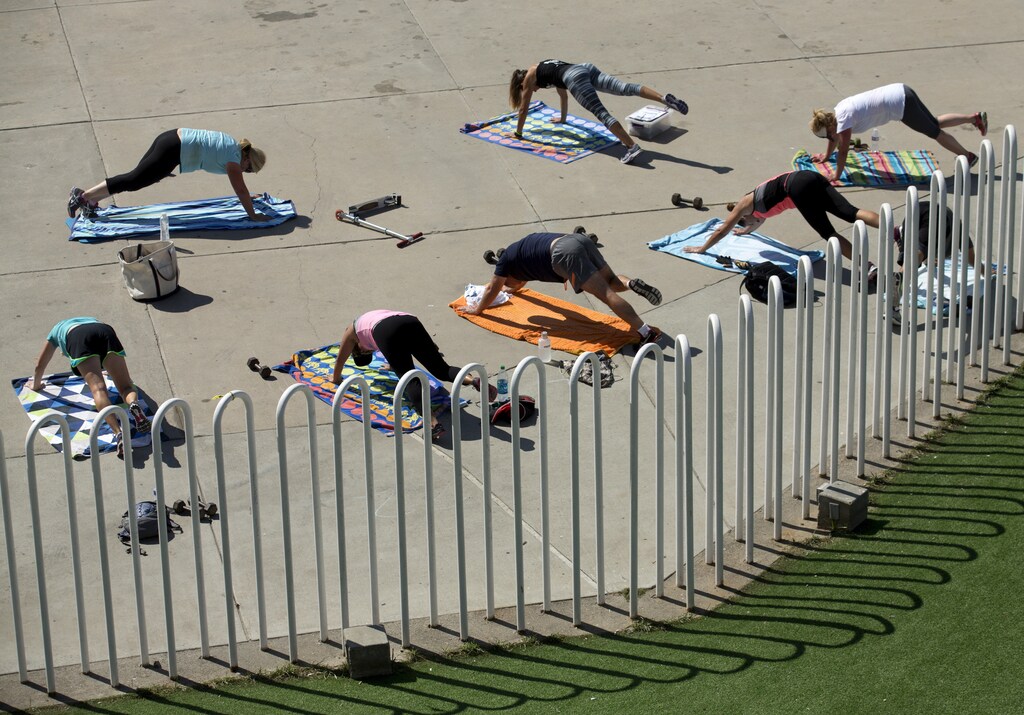 People participate in an outdoor fitness class at the beach in Oceanside, California, August 14, 2015. REUTERS/Mike Blake - GF10000174196