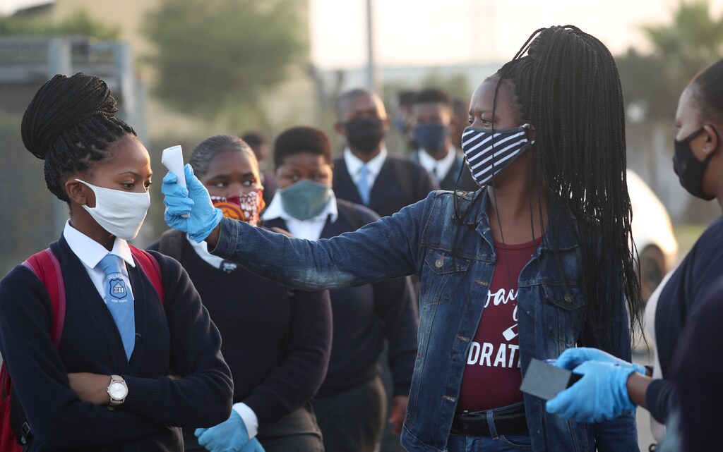 A teacher screens students as schools begin to reopen after the coronavirus disease (COVID-19) lockdown in Langa township in Cape Town, South Africa June 8, 2020. REUTERS/Mike Hutchings - RC2X4H9294C4