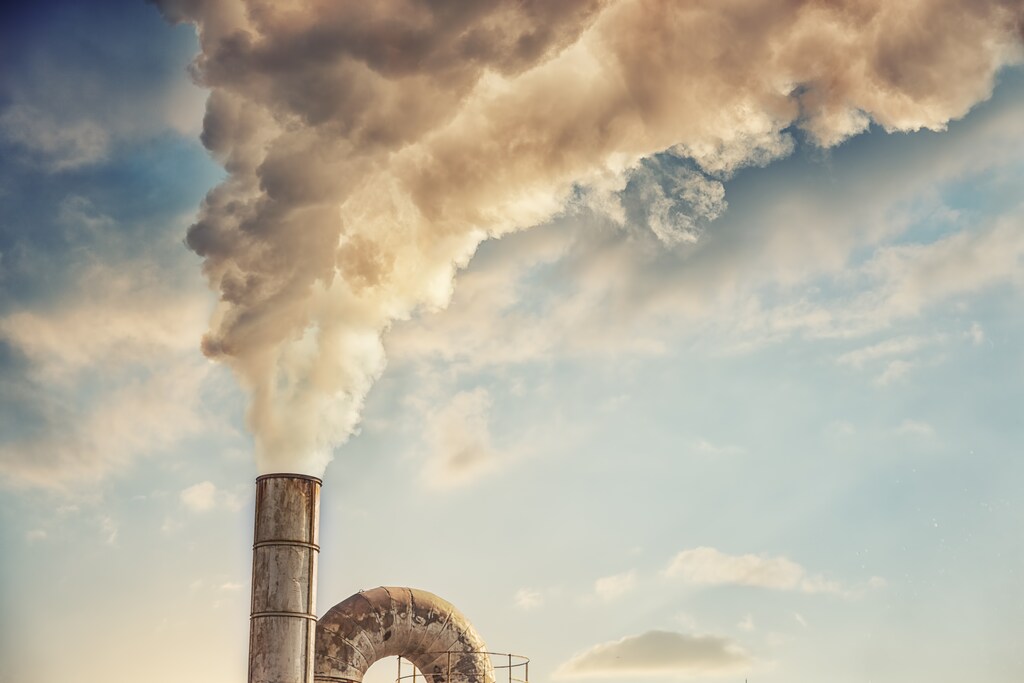 A chimney belches smoke: climate change.