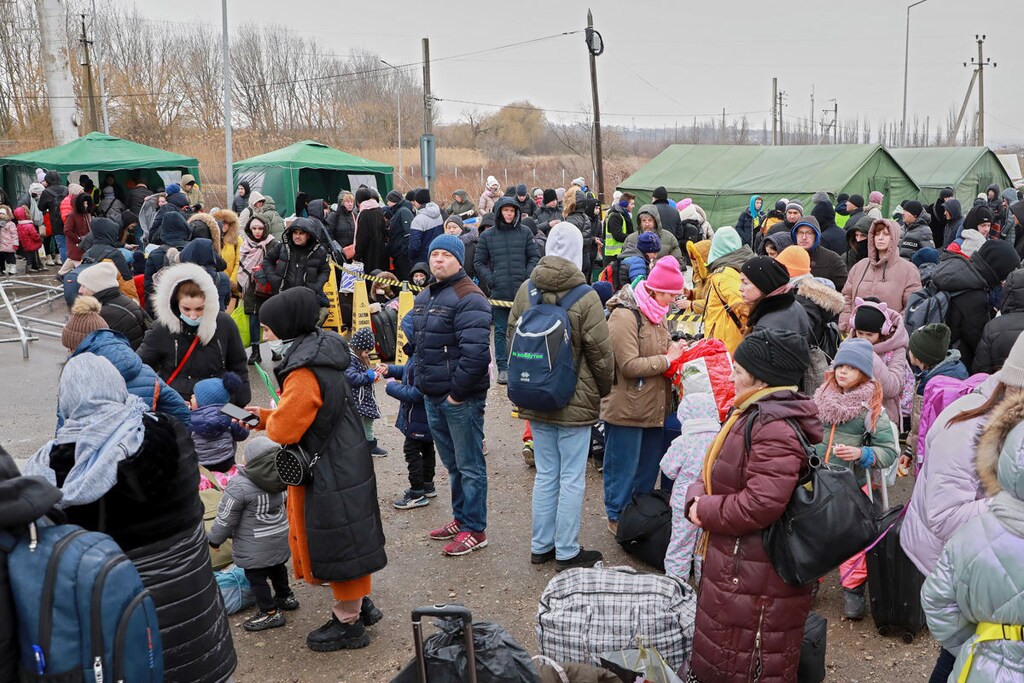 Ukrainians queue for humanitarian assistance.