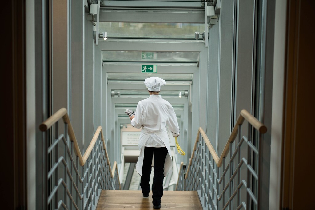 Chef walking down a set of stairs.