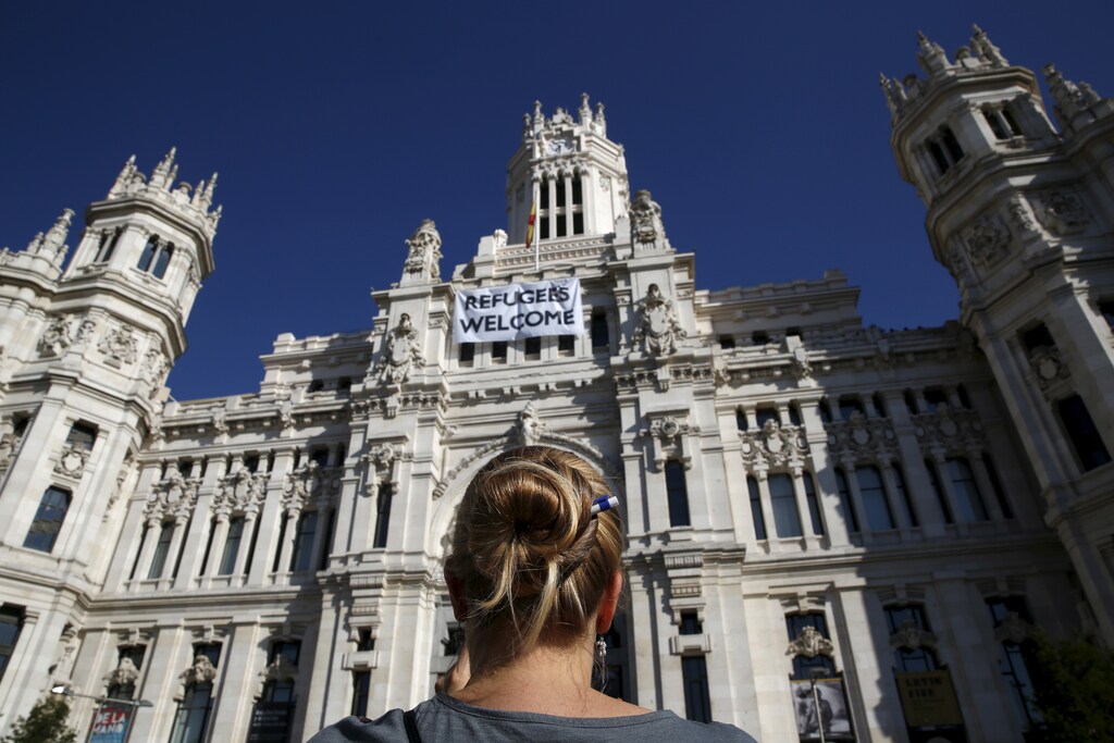 A woman stands outside Madrid's Town Hall, where a banner welcoming refugees is displayed, in Madrid, Spain, September 8, 2015. Spain is ready to accept as many refugees as proposed by the European Commission, the country said on Tuesday, a sharp change of heart after arguing it was being asked to take too many. REUTERS/Susana Vera - RTX1RONO
