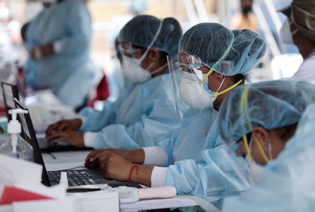 Healthcare workers register people to be tested for the coronavirus disease (COVID-19) as Peru raised its pandemic alert level in various cities and tightened some restrictions, due to a third wave of infections caused by the spread of the Omicron variant, in Lima, Peru January 6, 2022. REUTERS/Angela Ponce