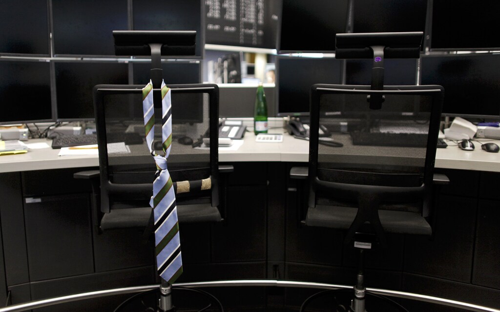 A tie hangs from an empty chair on a trader desk after the end of a trading day at the Frankfurt stock exchange August 12, 2011. REUTERS/Alex Domanski (GERMANY - Tags: BUSINESS IMAGES OF THE DAY) - GM1E78D02RY01