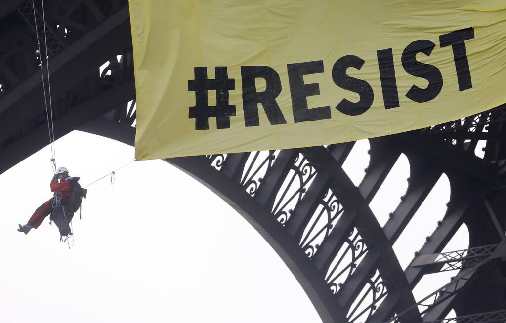 Activists from the environmentalist group Greenpeace unfurl a giant banner on the Eiffel Tower in a call on French citizens to vote against the National Front (FN) presidential candidate Marine Le Pen, in Paris, France, May 5, 2017. REUTERS/Mal Langsdon - RTS1595E
