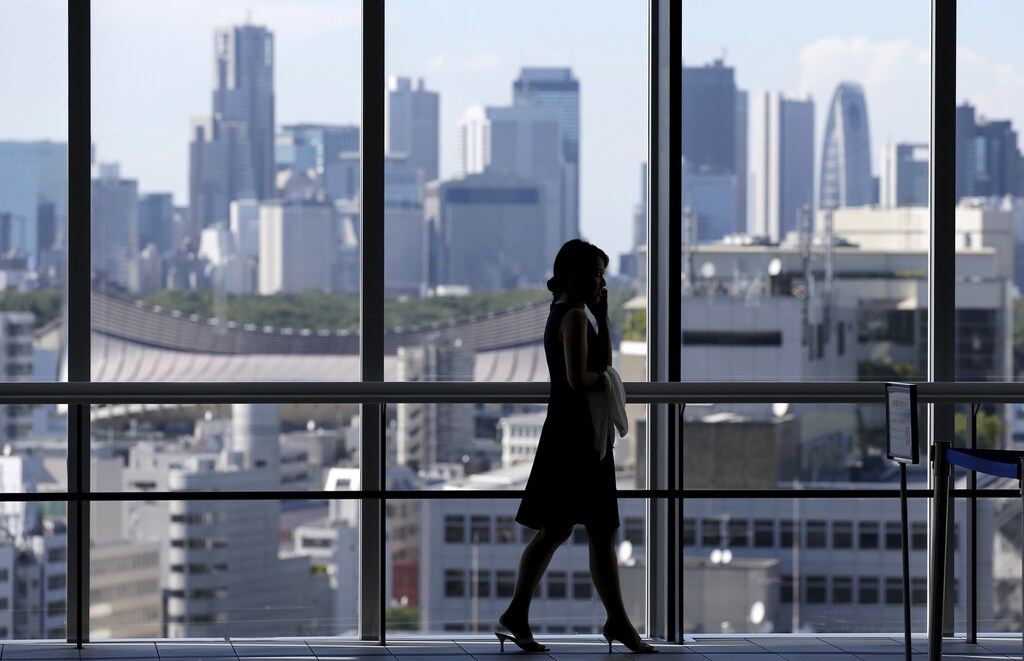 A woman uses her mobile phone at an office building in Tokyo July 21, 2015. Two in five Japanese firms plan to boost capital spending this business year, and more than a third of those say it is because of rising demand, a Reuters poll showed, pointing to a pickup in confidence about the economy. Picture taken July 21, 2015. REUTERS/Toru Hanai - GF10000165729