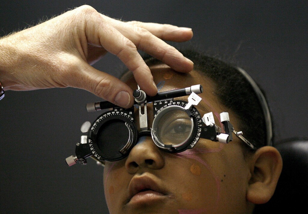 A doctor checks the eyesight of Carin Bell, one of a group of about 50 children who were being tested at the Red Cross Children Hospital in Cape Town, October 11, 2007. World Sight Day 2007 is observed on October 11 and focuses on the issues of childhood blindness. REUTERS/Mike Hutchings (SOUTH AFRICA) - GM1DWIROVTAA